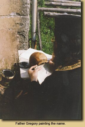 Father Gregory painting the name.