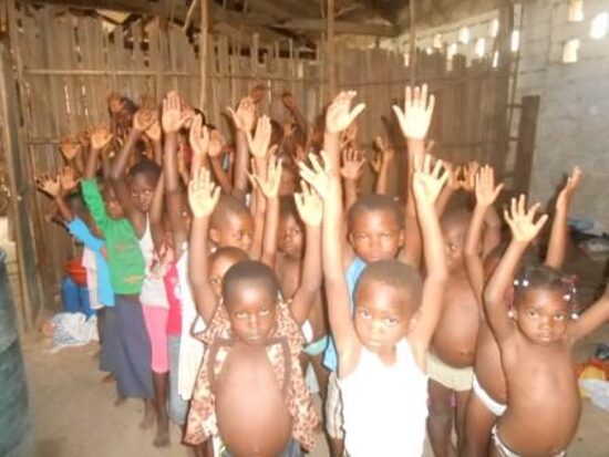 Children raising their hands before their baptism