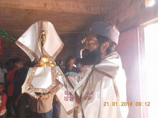 Father Theophile in vestments at the altar, the chalice covered with the veil