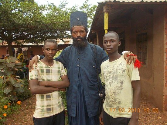 Father Theophile with two young men of the parish
