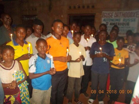 Children and young people holding lit candles by night