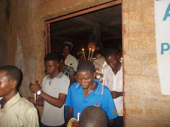 The faithful coming out of the church door with candles