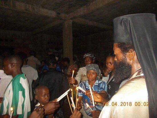 Father Theophile giving the Paschal light to the faithful, who light their candles from his