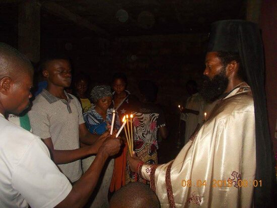 Father Theophile giving the Paschal light to the faithful, who light their candles from his