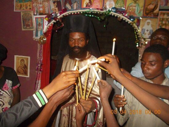 Father Theophile giving the Paschal light to the faithful, who light their candles from his