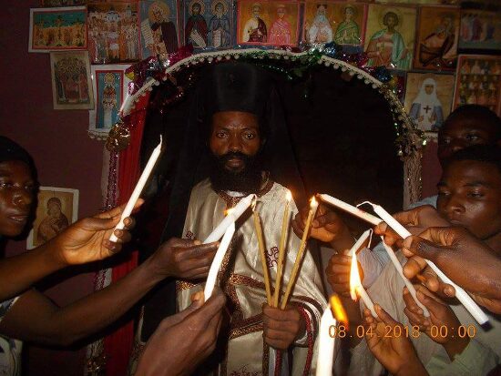 Father Theophile giving the Paschal light to the faithful, who light their candles from his